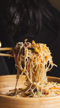 Nouilles sautées asiatiques avec viande et légumes dans un bol en bois, spécialité du restaurant asiatique BOLKIRI.