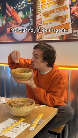 Client dégustant un plat asiatique dans un restaurant BOLKIRI Paris 11 Street Food Viêt, ambiance décontractée à l'intérieur.