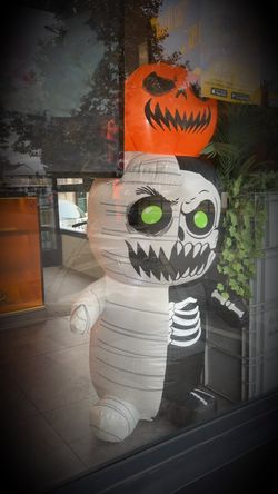 Figurine gonflable décorative avec tête de citrouille et corps moitié squelette, moitié momie dans un restaurant asiatique