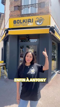 Façade du restaurant asiatique BOLKIRI avec une enseigne jaune et une personne en t-shirt noir devant l'entrée.