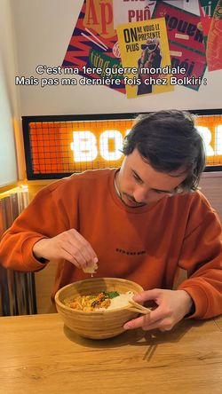 Client dégustant un plat asiatique dans le restaurant BOLKIRI Roubaix Street Food Viêt avec décor coloré en arrière-plan.