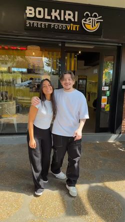 Deux personnes souriantes posent à l'entrée du restaurant BOLKIRI Les Mureaux.