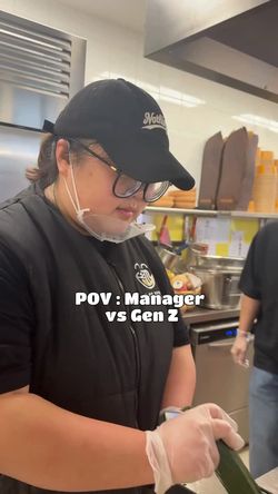 Personne en uniforme et casquette dans la cuisine d'un restaurant asiatique BOLKIRI Saint-Gratien préparant de la nourriture.