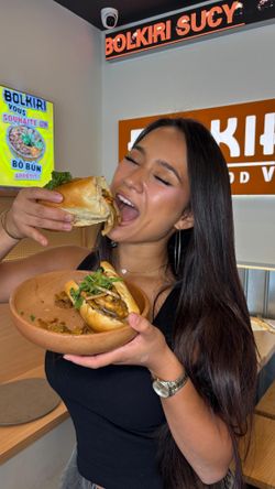 Femme dégustant un sandwich dans un restaurant asiatique BOLKIRI Melun Street Food Viêt.