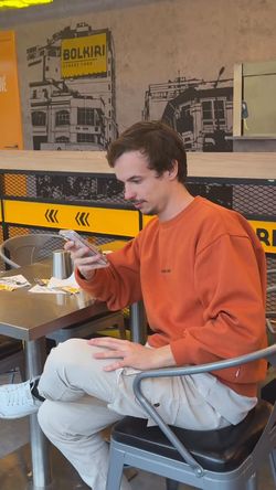 Client dans le restaurant asiatique BOLKIRI Bourg-la-Reine mangeant à une table intérieure avec décor urbain visible.