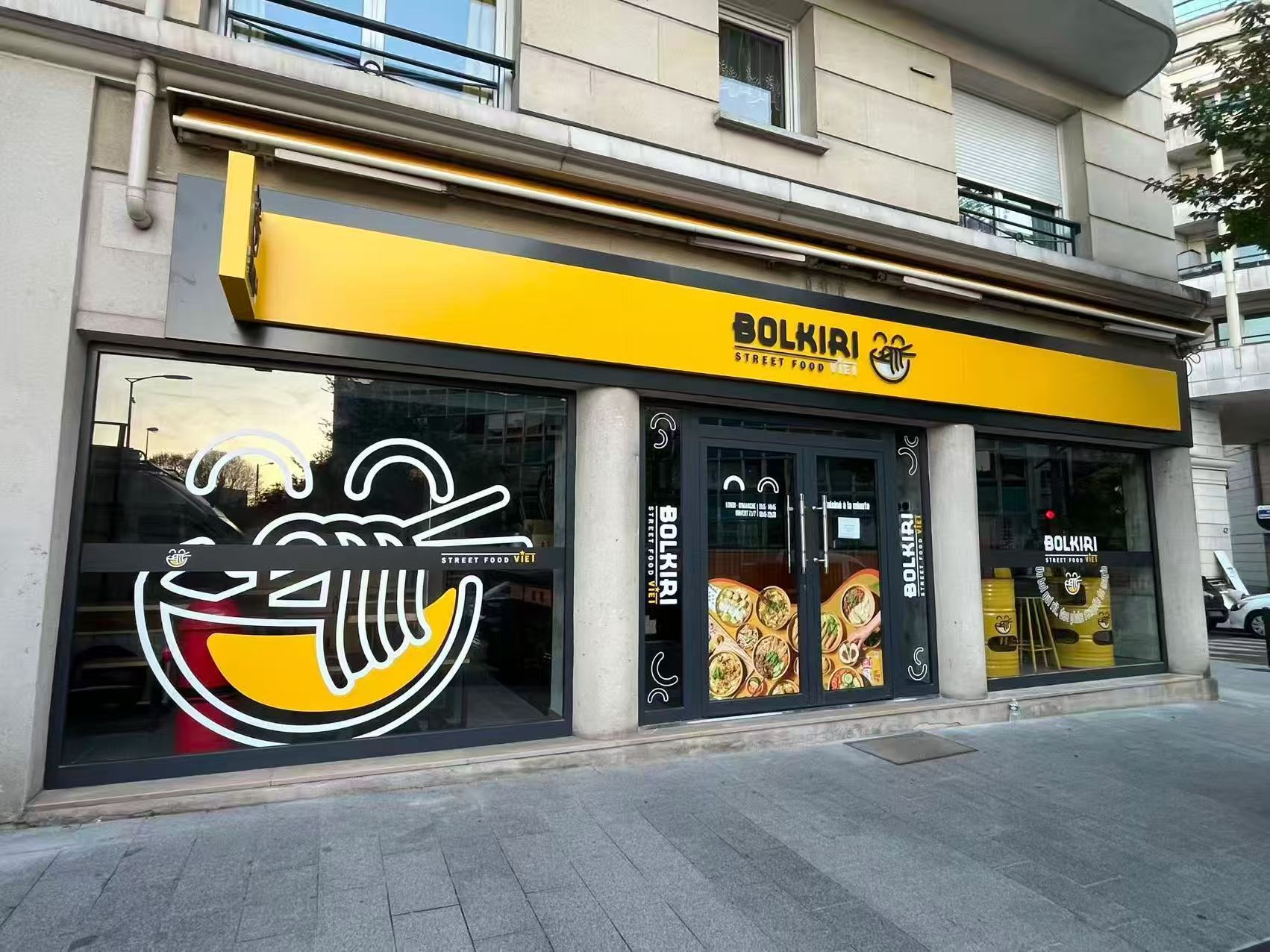 Façade du restaurant asiatique BOLKIRI à Bourg-la-Reine avec une enseigne jaune et des illustrations de nouilles.