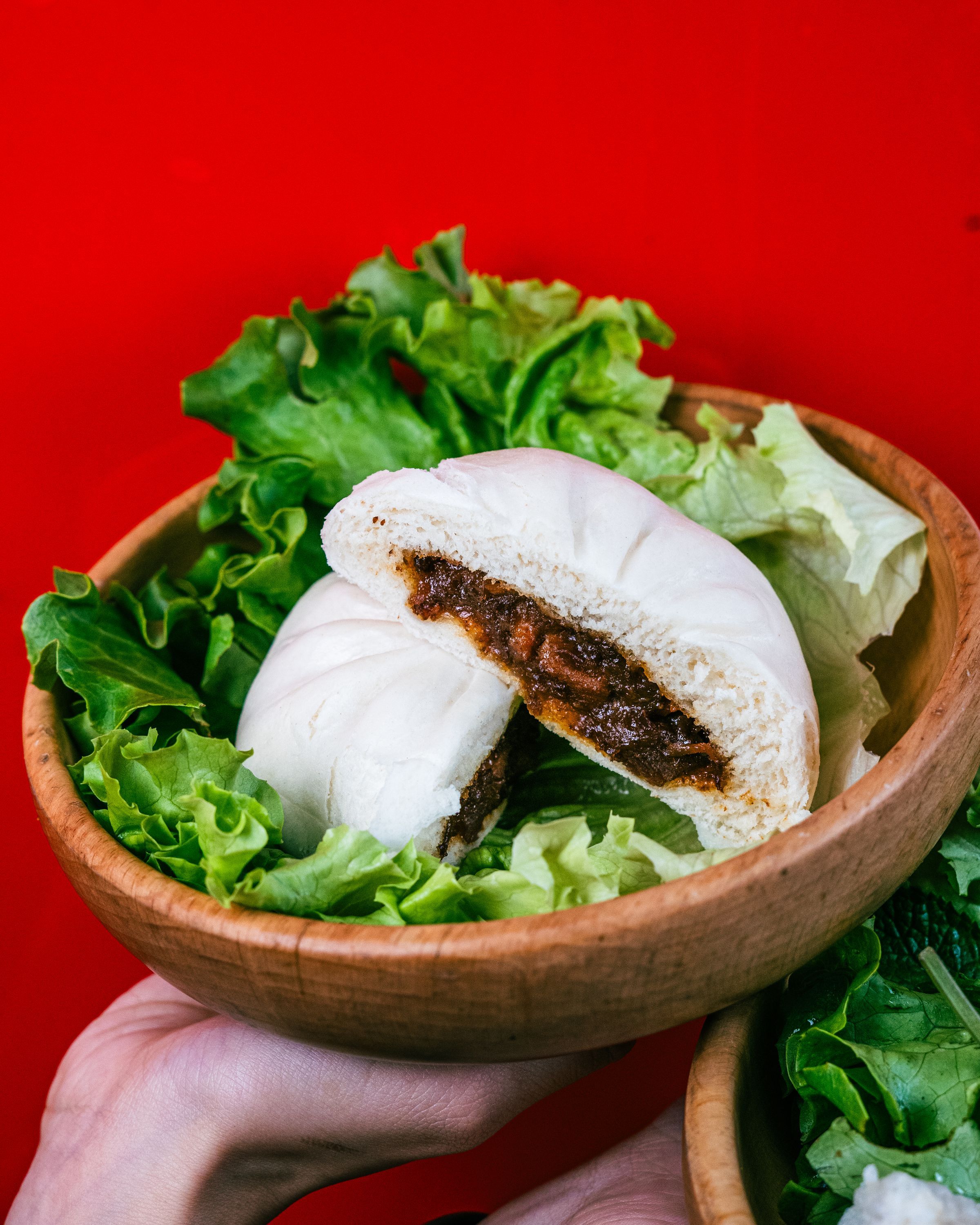 Bun dans un bol en bois, garni de salade verte, mettant en avant une spécialité de street food vietnamienne.