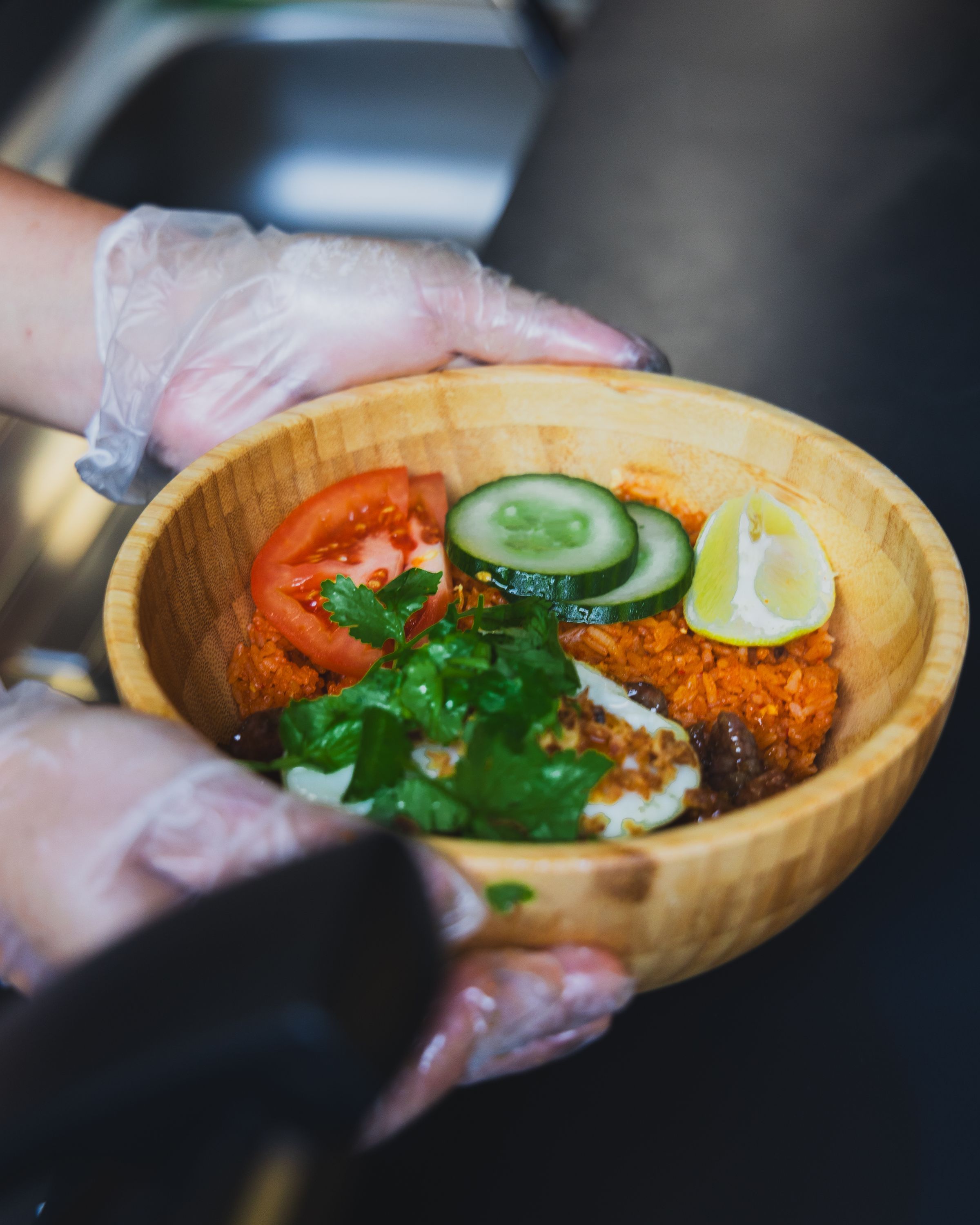 Bol en bois avec du riz, légumes frais et corainder, spécialité de cuisine vietnamienne.