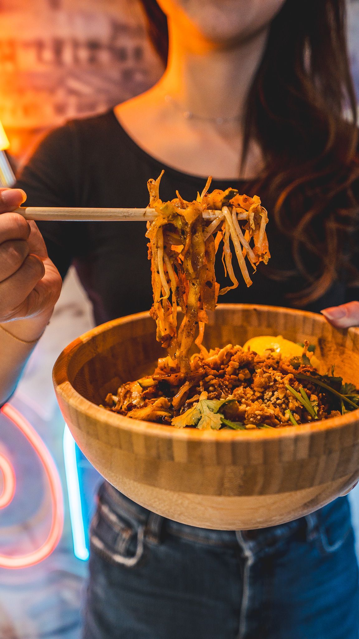 Un plat de street food vietnamienne dans un bol, servi avec des nouilles et des herbes aromatiques.