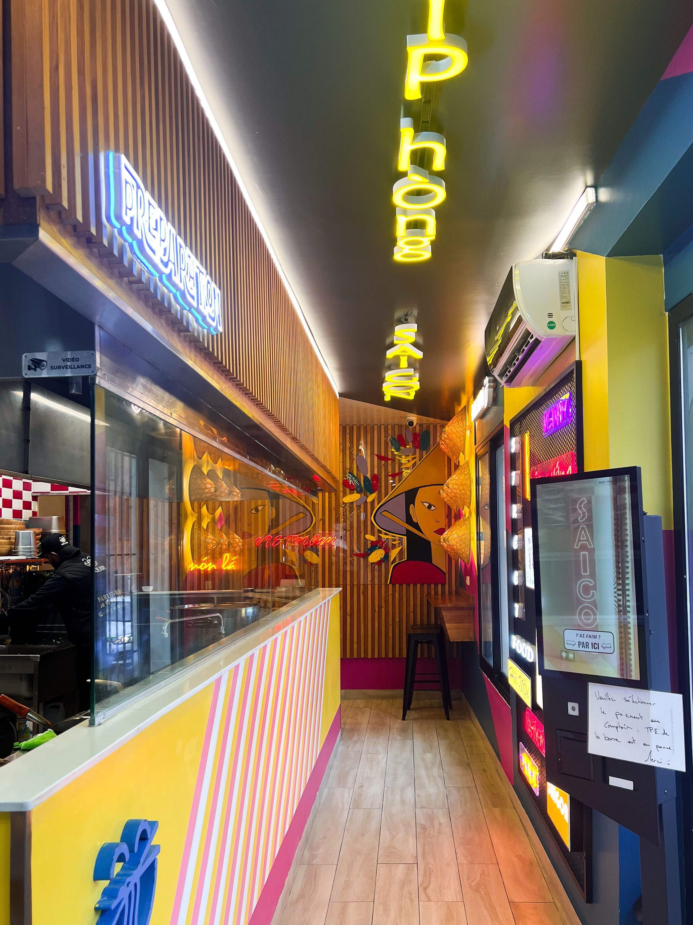 Intérieur coloré du restaurant BOLKIRI avec décor street food et affichages lumineux.