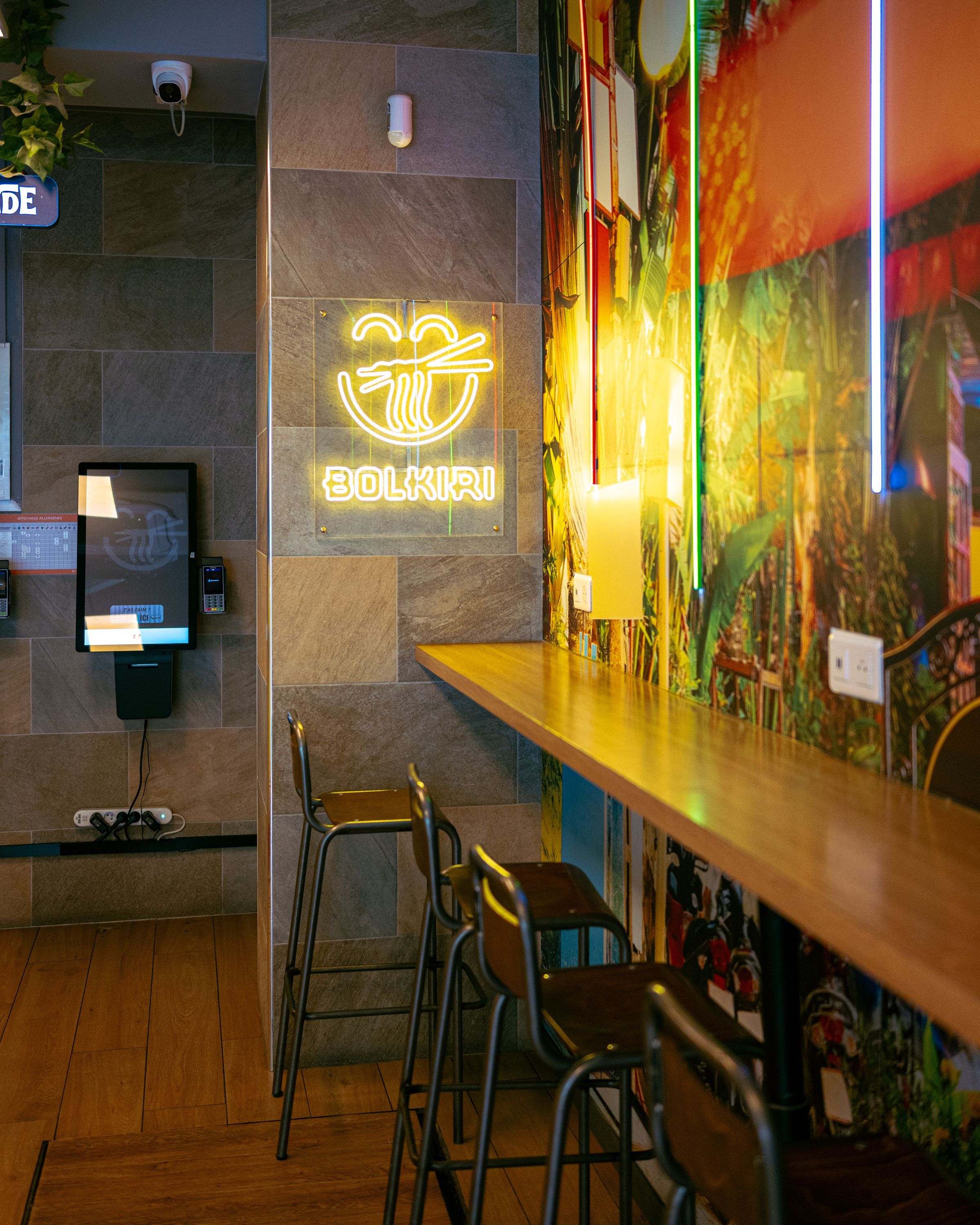 Ambiance moderne avec des sièges autour d'un comptoir en bois dans le restaurant asiatique BOLKIRI.