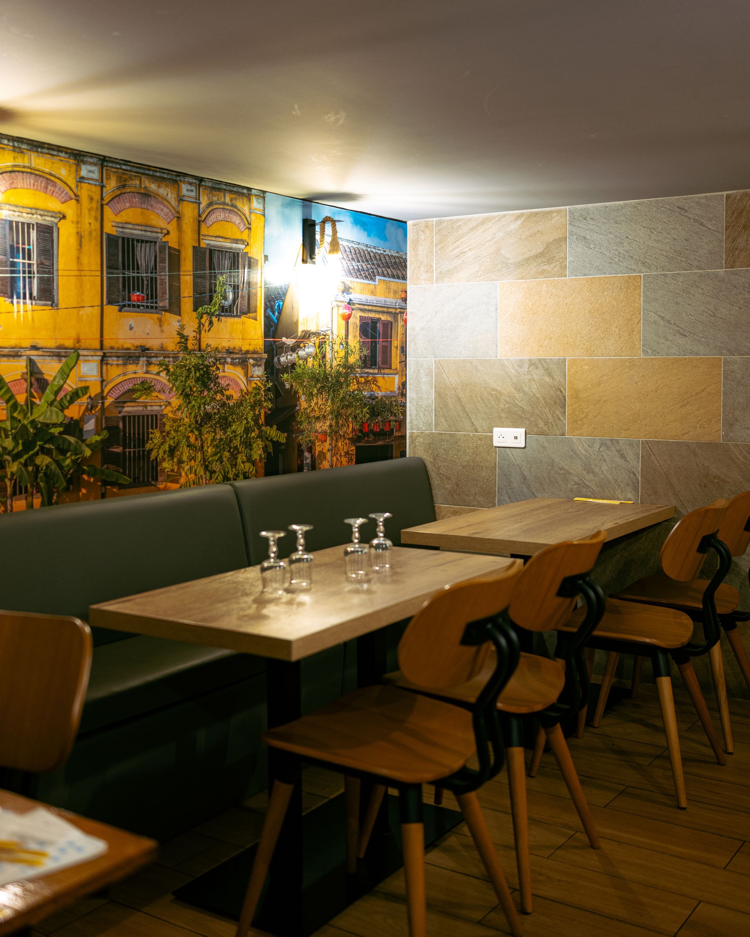 Ambiance accueillante avec bancs en cuir et décor aux couleurs vives inspiré de la cuisine vietnamienne.