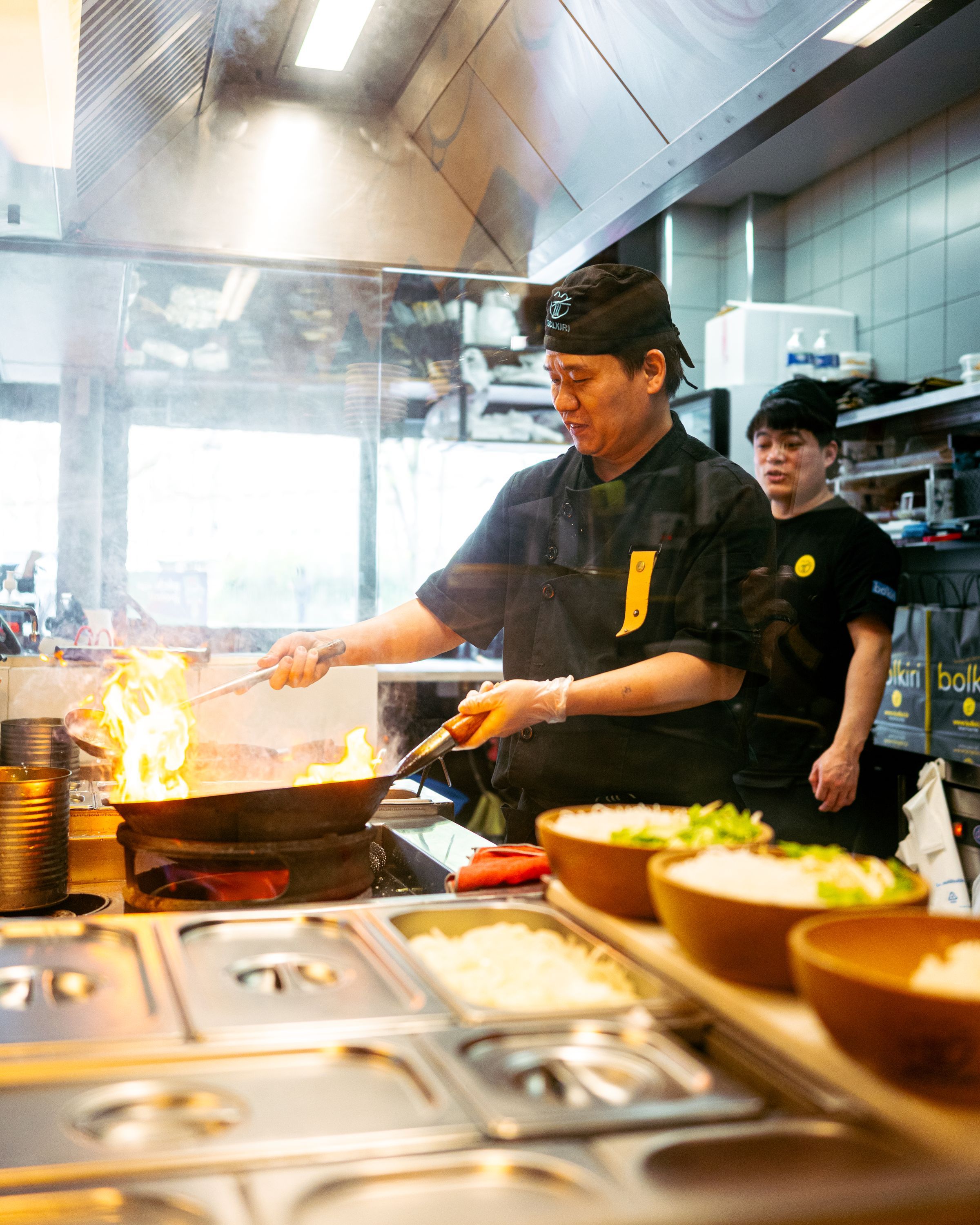 Préparation de plats au restaurant asiatique BOLKIRI, mettant en avant la cuisine vietnamienne et street food.