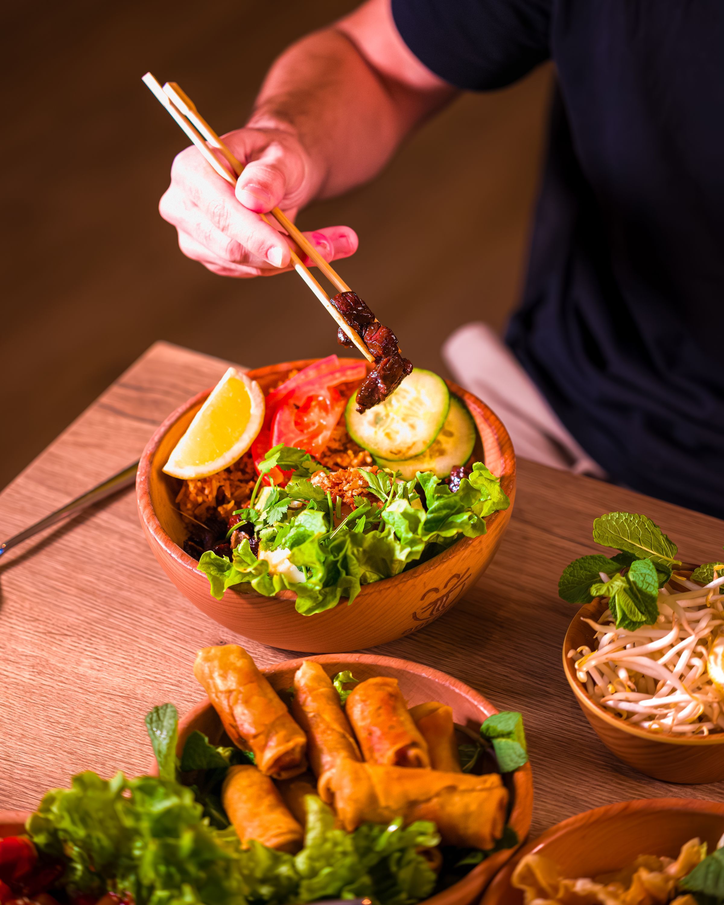 Plat de cuisine vietnamienne avec saladier de légumes frais et rouleaux de printemps.