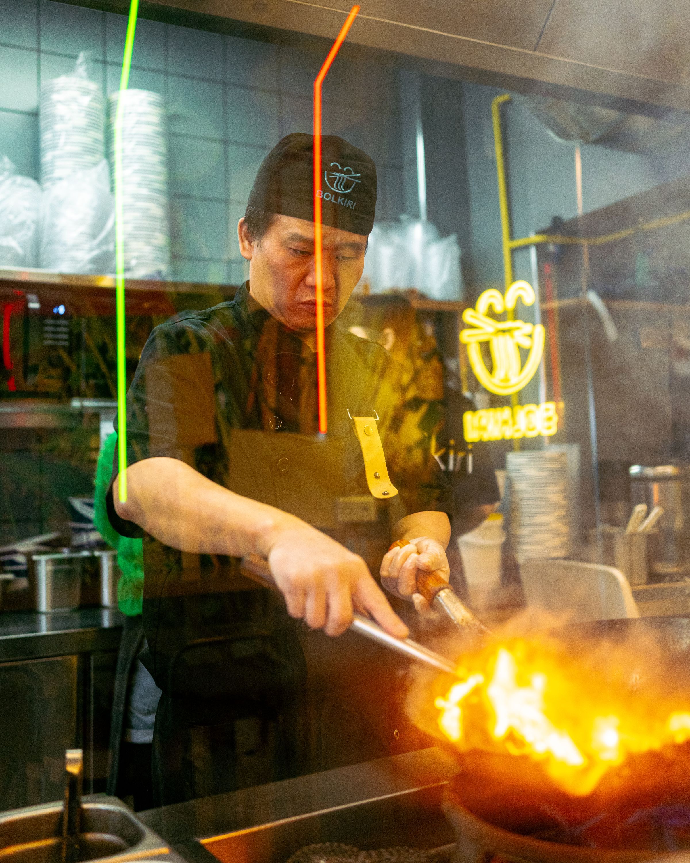 Un chef préparant des plats vietnamiens dans un restaurant asiatique de street food.