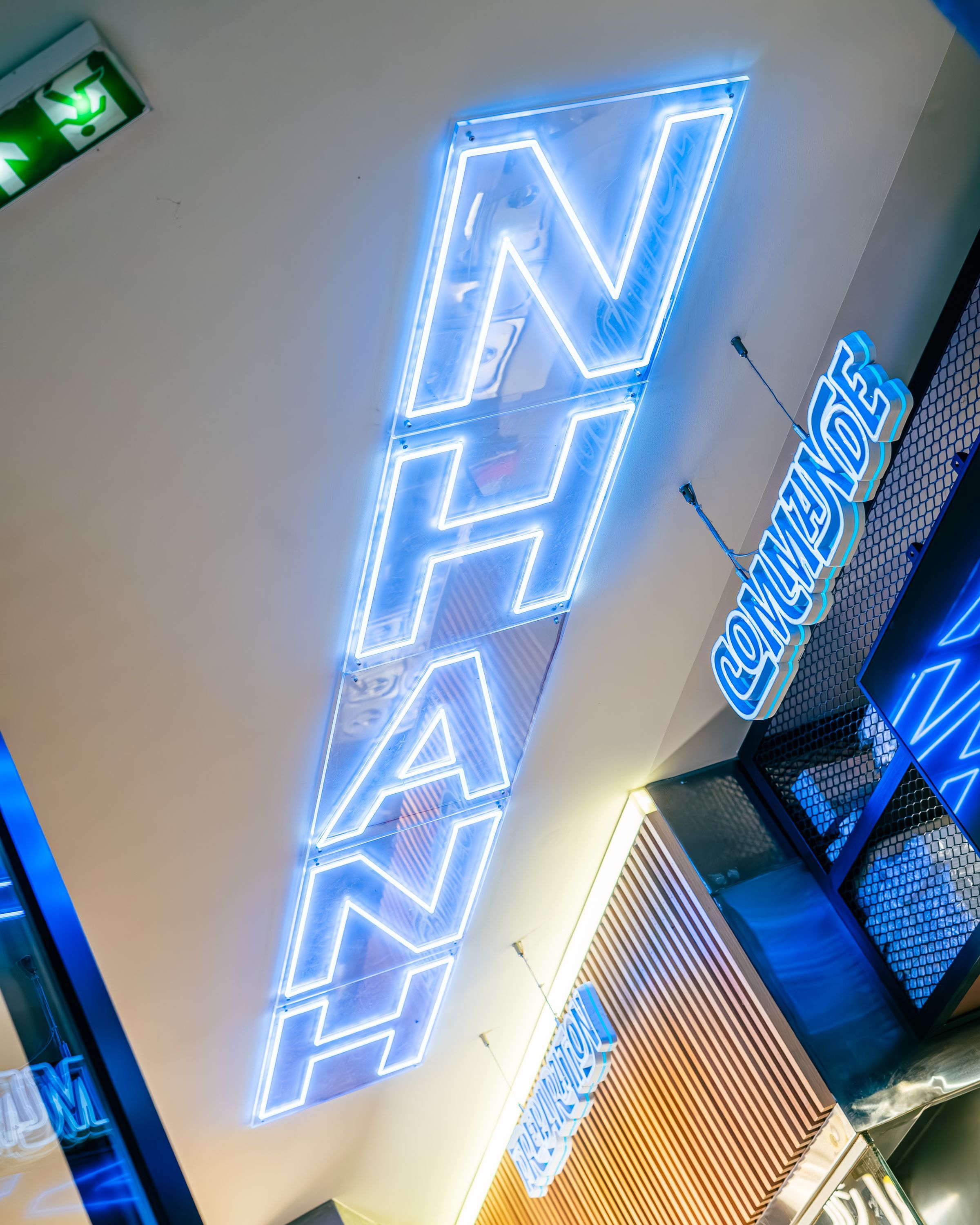 Enseigne néon lumineuse avec le mot 'NHANH', ambiance street food asiatique.